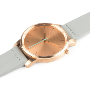 All rose gold Hervor watch with dove grey leather strap and a turquoise accent second hand