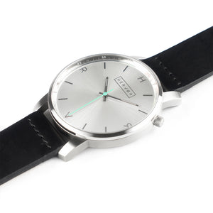 All silver Hervor watch with black leather strap and a turquoise accent second hand