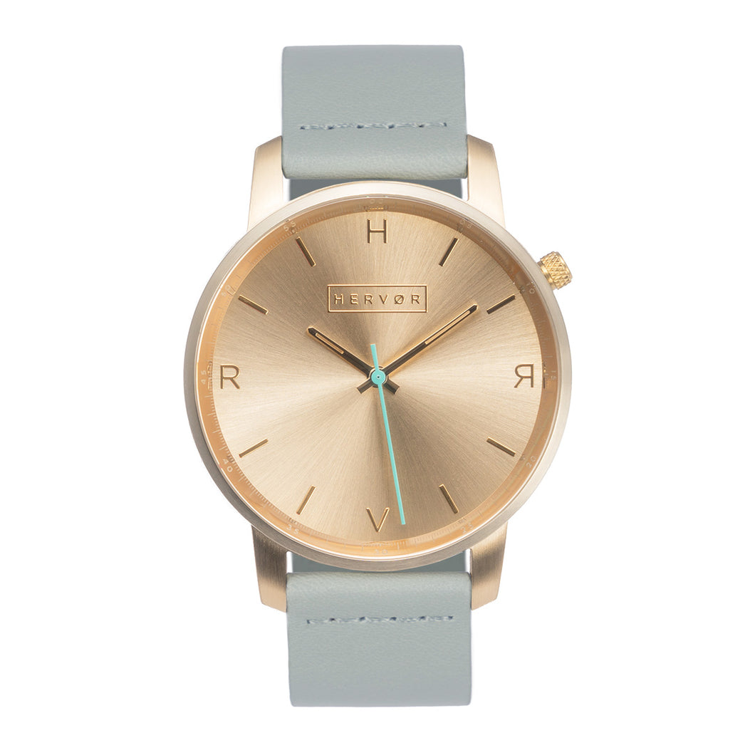 All gold Hervor watch with dove grey leather strap and a turquoise accent second hand