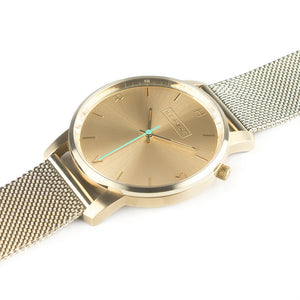 All gold Hervor watch with gold metallic mesh strap and a turquoise accent second hand