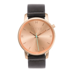 All rose gold Hervor watch with black leather strap and a turquoise accent second hand