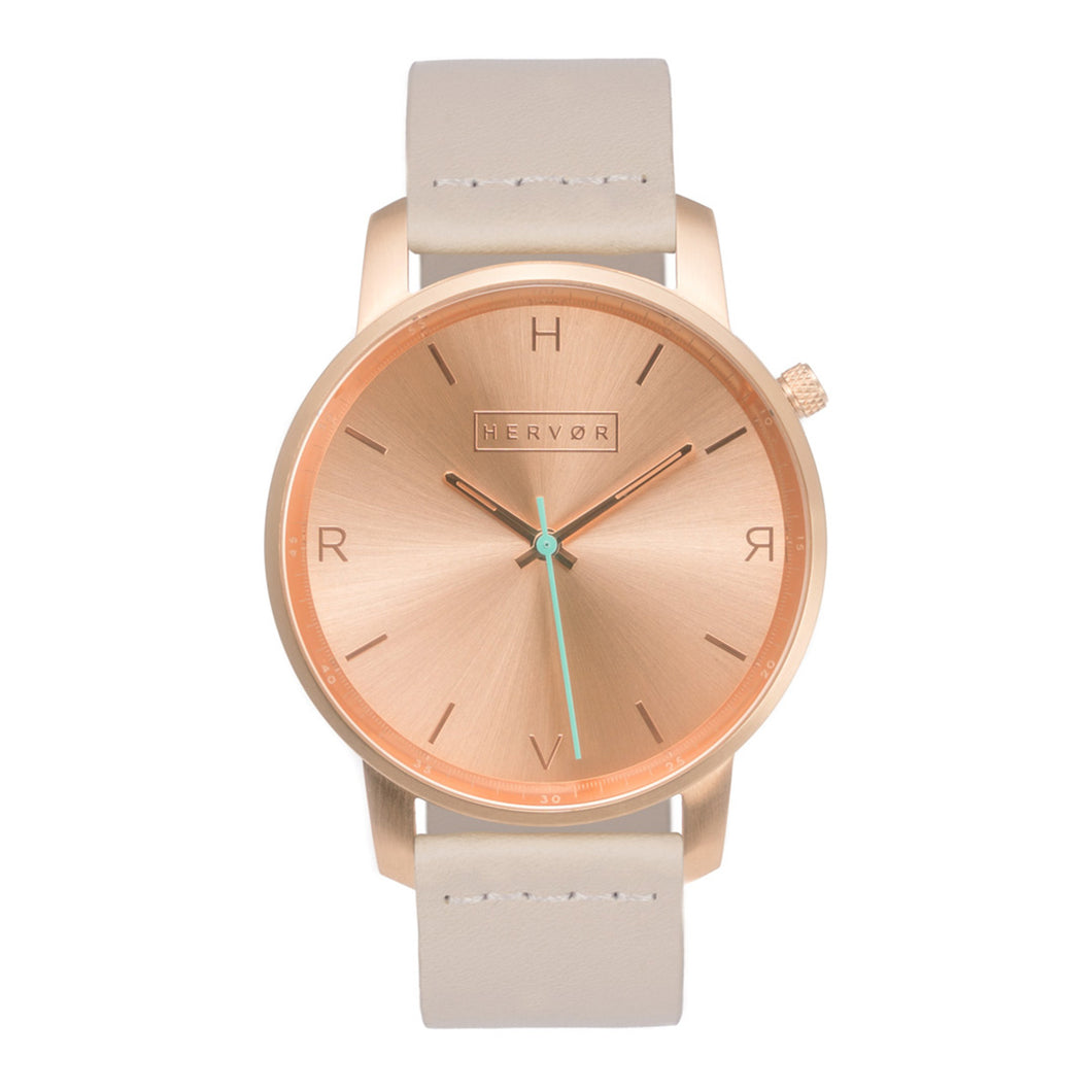 All rose gold Hervor watch with light pink skin tone leather strap and a turquoise accent second hand