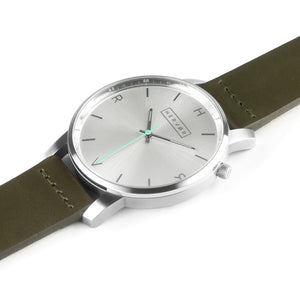 All silver Hervor watch with olive khaki green leather strap and a turquoise accent second hand