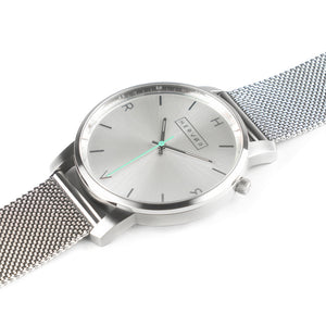 All silver Hervor watch with silver metallic mesh strap and a turquoise accent second hand