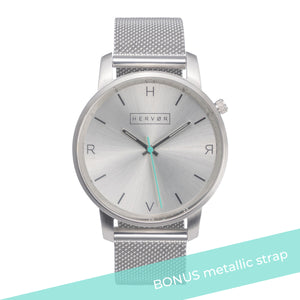 All silver Hervor watch with silver metallic mesh strap and a turquoise accent second hand